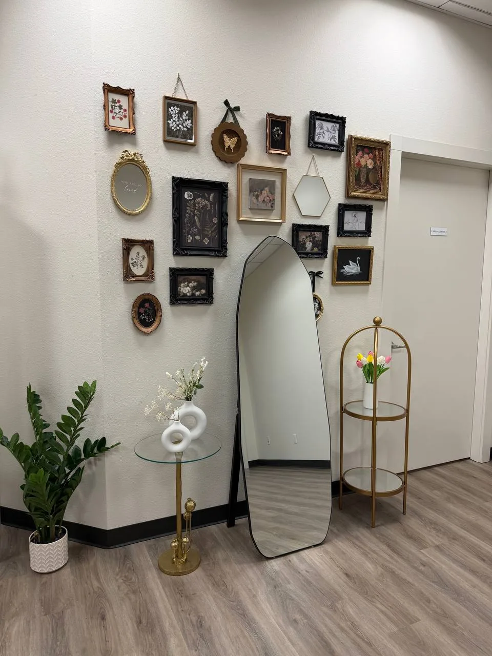 Waiting area with gallery wall and full-length mirror at Beautissima